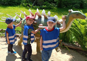 Chłopcy stoją obok dinozaura
